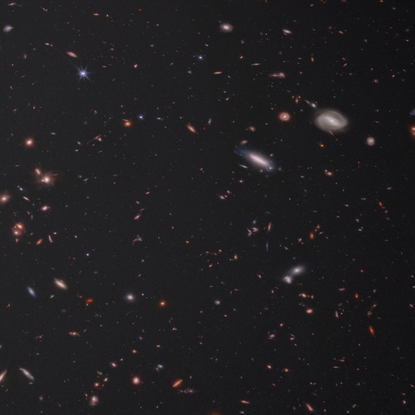 Hundreds of small galaxies against the black background of space